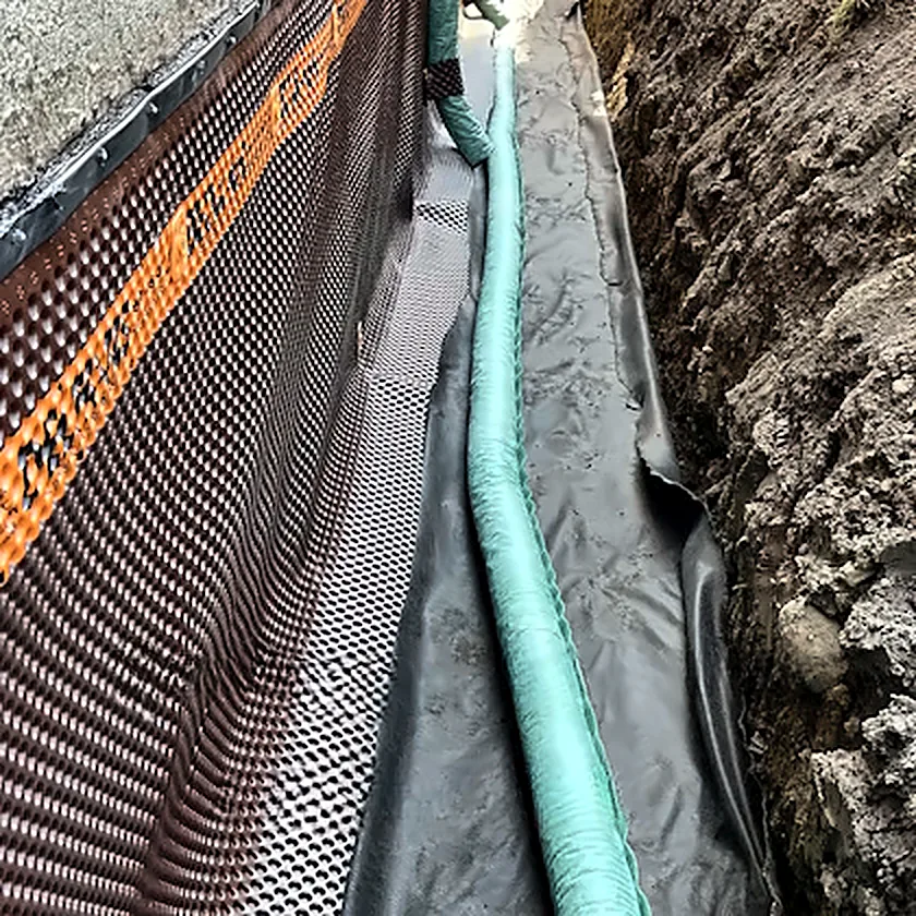 Drain français et membrane installés le long d’une fondation